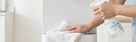 Người dùng đang vệ sinh cọc cắm và khay hứng nước cây nước